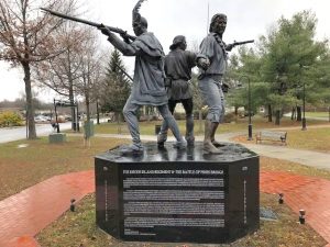 A statue depicting three Revolutionary War-era military members